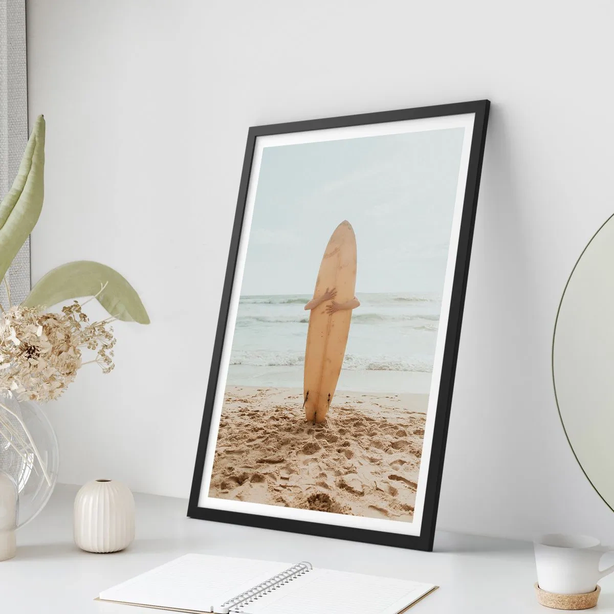 Affisch i svart ram - En person som håller en surfbräda på en strand med utsikt över havet. - 50x70cm - Av kärlek till vågorna - Modern väggdekoration för vardagsrum och sovrum ARTTOR